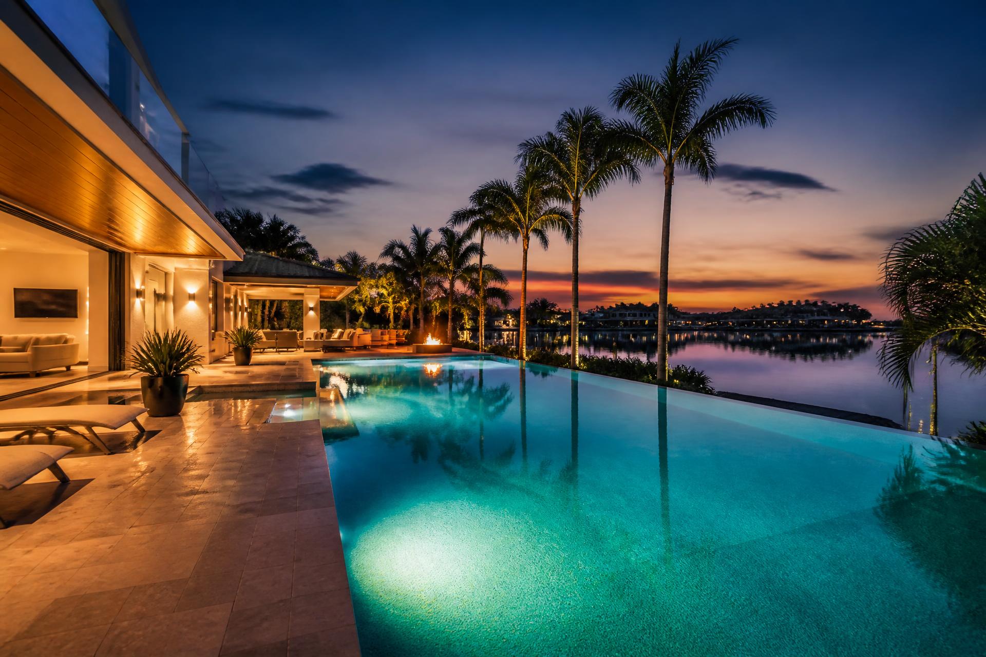 Sparkling clean residential pool at twilight with palms and lit deck in Sarasota, Florida